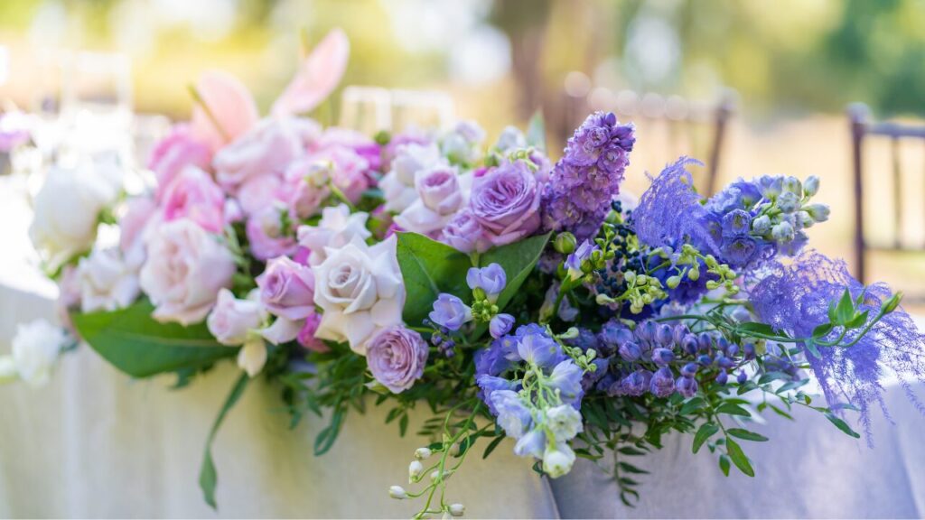 Bouquets of fresh flowers decoration of the festive table. Celebrating an open air party. Decor Details